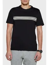Remera negra de algodón regenerativo con cuello redondo, dos rayas horizontales blancas en el pecho, logo monotipo de Tommy Hilfiger en el pecho y bandera de Tommy Hilfiger bordada en la manga.