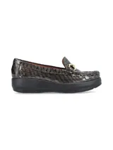 Mocasín de cuero charol negro con plataforma blanca y detalle de hebilla metálica plateada en el empeine.