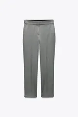 Pantalón gris de vestir, de corte tobillero, con tiro medio, cintura elástica en la parte trasera, bolsillos delanteros y falsos bolsillos traseros.