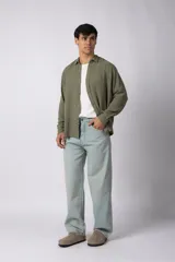 Camisa de lino blanca de manga larga, con cuello clásico y cierre frontal con botones. Corte recto y holgado.