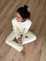 Conjunto de sweater y pantalón de punto color crema con diseño trenzado.
