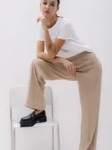 Pantalón de vestir color beige, de corte recto y pierna ancha, con detalle de pinzas al frente.