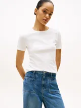 Remera blanca de corte slim, cuello redondo y manga corta. Presenta un logo estampado en el pecho.