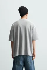 Camiseta azul marino de corte holgado, confeccionada en algodón con cuello redondo y mangas cortas. Presenta un efecto de lavado que le da una apariencia única.