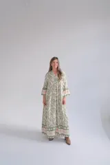 Vestido largo verde con estampado abstracto en tonos claros, corte amplio, cuello mao y mangas 3/4 acampanadas.