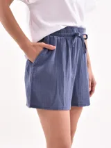 Short celeste de tejido arrugado con cintura elastizada y lazo de ajuste.