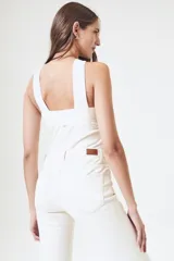 Top cruzado color arena, ajustado al cuerpo, con tirantes anchos y diseño elegante.