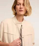Campera bomber negra de viscosa con cierre delantero, bolsillos con solapa y pespuntes contrastantes en color blanco.