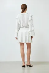 Minifalda blanca de bambula con volados y cintura elastizada.