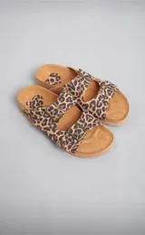 Sandalias bajas con estampado animal print, doble tira con hebilla ajustable y suela plana.