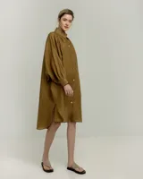Vestido camisero color ocre de ramio, con cuello mao, mangas largas abullonadas y cierre frontal con botones.