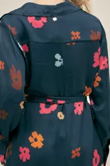 Vestido largo camisero azul marino con estampado floral multicolor, botones nacarados, bolsillos laterales, aberturas laterales y cinturón de lazo.