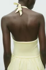 Vestido corto marrón con cuello halter con lazada y escote pico.