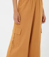 Pantalón pantalona color marrón, de lino y viscosa, con cintura elástica, bolsillos laterales y corte amplio.