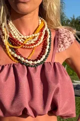 Conjunto de top corto con breteles y falda larga con volados, color rosado. Ambas piezas tienen elástico en la cintura y en el bajo pecho.