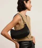 Bolso baguette pequeño color negro, con textura embossed y estampa triangular. Tiene asa mediana ajustable y cierre de cremallera.