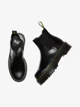 Botas Chelsea Dr. Martens modelo 2976 Quad, de cuero negro pulido, con elásticos laterales, plataforma de 4 cm y costuras amarillas.