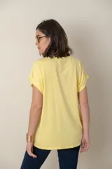 Blusa italiana color celeste con bordado de plumas al tono en el frente, confeccionada en lino y algodón.