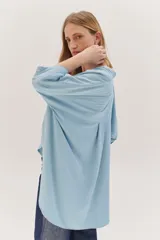 Sobrecamisa celeste de corte recto, con cuello mao, mangas 3/4 con puños y cierre frontal con botones. Tiene dos bolsillos de parche en el pecho.