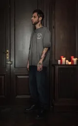 Remera gris de manga corta y cuello redondo, con calce oversize y estampado sublimado de una ilustración con una mujer, espadas y rosas.