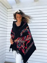 Chal negro de cachemir con bordados florales multicolores y flecos en los bordes.