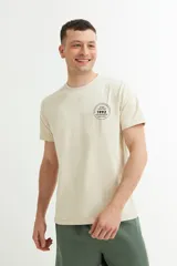 Remera color beige con estampado circular en el pecho con texto en negro.