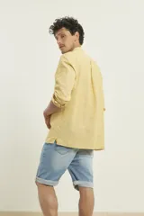Camisa amarilla de lino con cuello mao y manga larga.