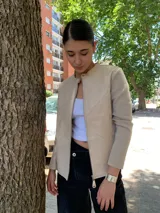 Campera color beige con mangas largas de tejido de punto y cuerpo de cuero sintético. Interior con estampado animal print.