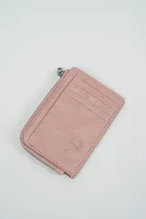 Billetera pequeña color gris claro con cierre de cremallera perimetral y tachas metálicas oscuras distribuidas en el frente.