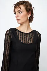 Vestido mini negro de líneas limpias y escote redondeado, con mangas largas de encaje.