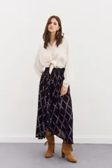 Falda larga de viscosa jacquard con lurex dorado, estampado geométrico, tajo central, ruedo irregular y cintura elastizada.