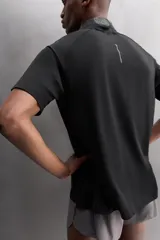 Camiseta deportiva verde militar confeccionada en tejido estructurado, ligero y elástico. Tiene cuello redondo, manga corta y bajo con aberturas laterales. Incluye logo estampado en el bajo.
