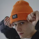 Gorro de lana blanco con etiqueta negra con el logo de la marca Pulau.