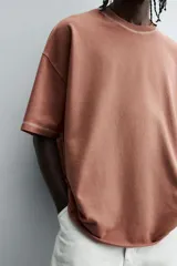 Camiseta color beige de corte holgado, cuello redondo y manga corta.