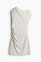 Vestido corto color gris claro, de punto elástico, con un solo hombro descubierto, escote asimétrico y frunces laterales que crean un efecto drapeado.