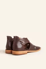 Sandalia de cuero color chocolate con tiras entrecruzadas y cierre trasero con cremallera.