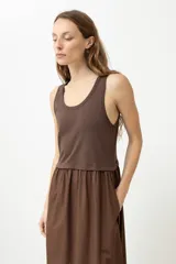 Vestido midi marrón con corte a la cintura, parte superior tipo musculosa y falda amplia.