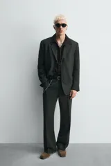 Botín de cuero negro con acabado serraje, cierre de cremallera lateral, horma cuadrada y tacón de 5 cm.