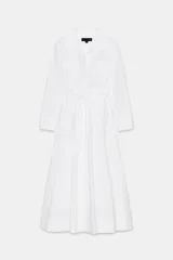 Vestido camisero midi blanco de la colección Zara Woman, con cuello solapa, escote en V, manga larga y bolsillos laterales ocultos. Presenta solapas decorativas en el pecho, cinturón de lazada en el mismo tejido y cierre frontal con botones.