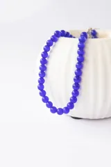 Collar de cuentas redondas de vidrio, color azul vibrante, con cierre metálico.