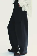 Pantalón cargo negro de corte amplio con cintura ajustable con cordón, bolsillos laterales y bolsillos tipo parche en las piernas.