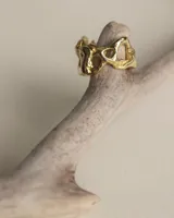 Anillo dorado con diseño abstracto y agujeros.