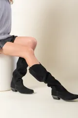 Bota de cuero negro con diseño elegante y suela de taco bajo, ideal para el uso diario.