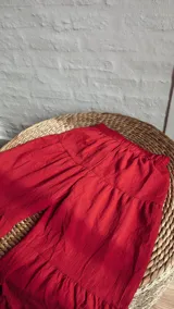 Pantalón palazzo rojo con cintura elástica y diseño escalonado.