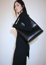 Vestido midi negro de punto de canalé, con cuello redondo y mangas largas.