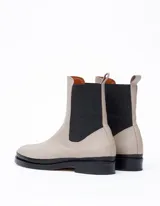 Bota Chelsea color crema de cuero vacuno, con elástico lateral negro, suela de cuero y taco de 2,5 cm. Hecha a mano en Argentina.