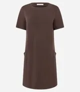 Vestido corto de mujer, estilo camiseta, color terracota/óxido, con escote redondo, mangas cortas y bolsillos laterales. El bajo es redondeado.