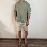 Bermuda color beige claro, estilo chino, confeccionada en gabardina. Presenta un corte recto y dobladillo en el ruedo.