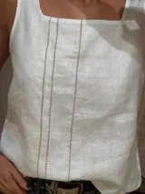 Musculosa blanca de lino con escote cuadrado y detalle de pespuntes verticales en el frente.