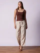 Pantalón de lino color beige, de corte recto, con pretina elastizada, lazo de ajuste y bolsillos delanteros y traseros.